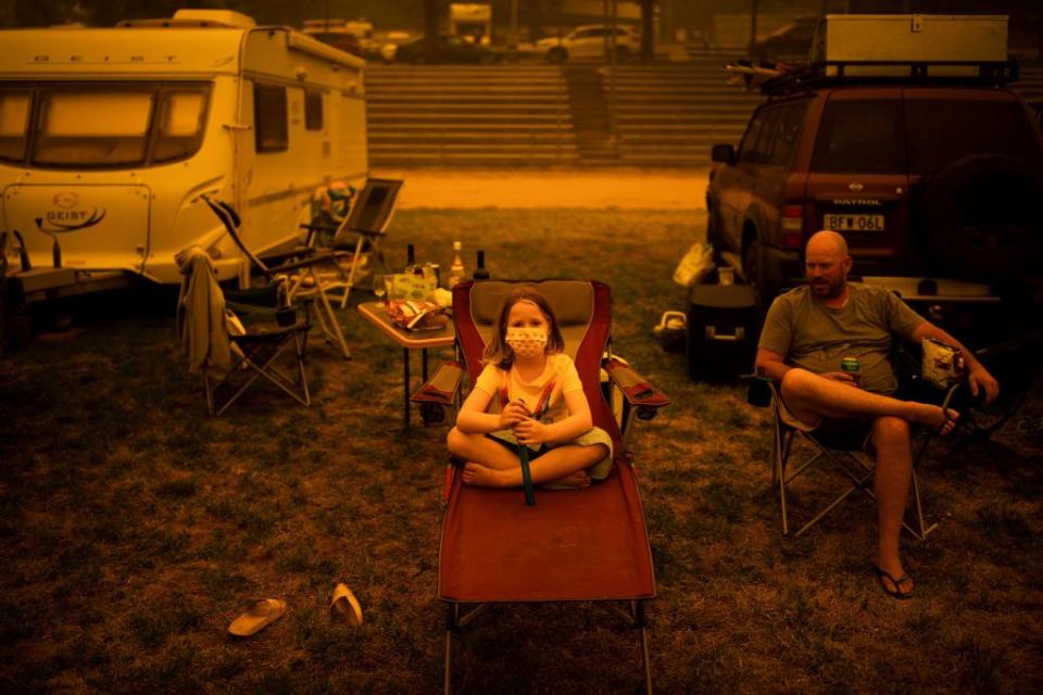 Amy and Ben Spencer sit at the show grounds in the southern New South Wales town of Bega where they are camping after being evacuated from nearby sites affected by bushfires. Source: Getty