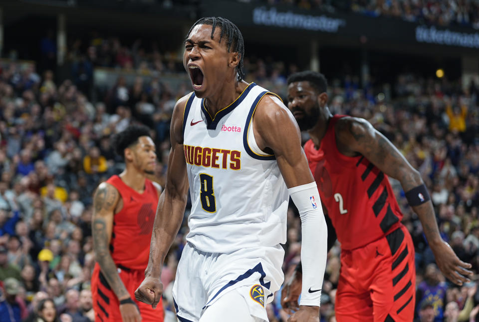 Denver Nuggets forward Peyton Watson (8) reacts after dunking as Portland Trail Blazers guard Anfernee Simons, back left, and center Deandre Ayton, right, look on in the second half of an NBA basketball game Sunday, Feb. 4, 2024, in Denver. (AP Photo/David Zalubowski)