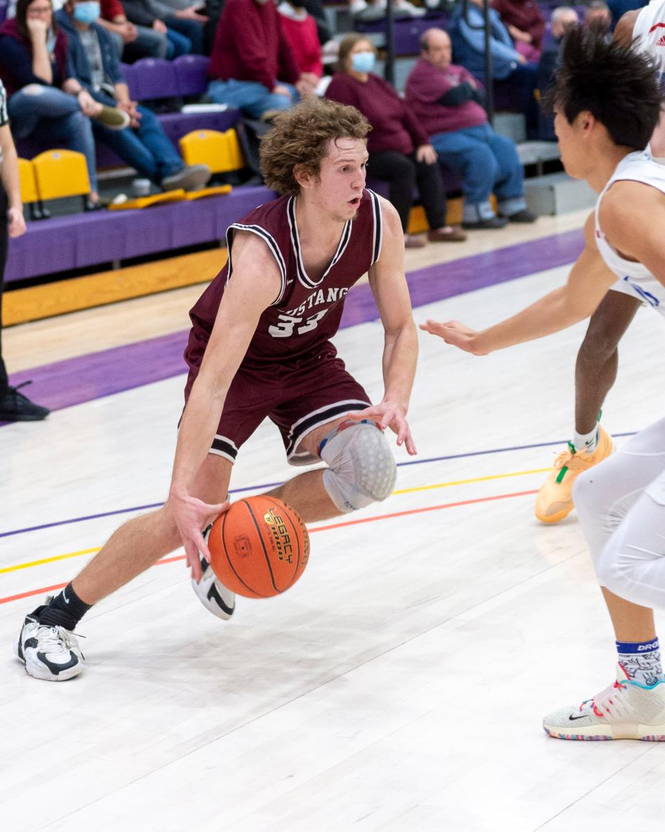 Nolan Puckett (33) drives against Andover Friday at Mabee Arena in the Mustangs' 62-58 loss in the semifinals of the Salina Invitational Tournament.