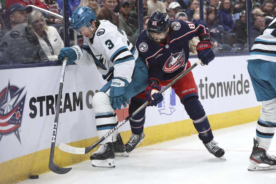 San Jose Sharks defenseman Henry Thrun (3) reaches for the puck in front of Columbus Blue Jackets forward Kirill Marchenko (86) during the second period of an NHL hockey game in Columbus, Ohio, Saturday, March 16, 2024. (AP Photo/Paul Vernon)