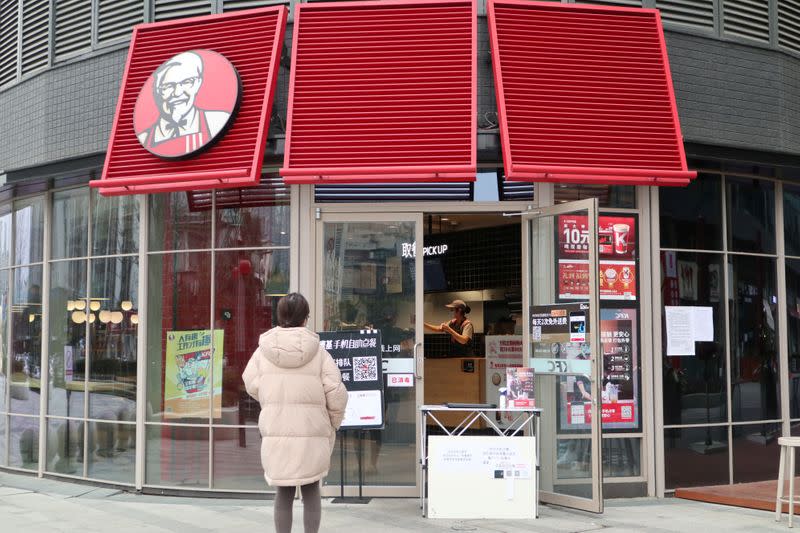 FILE PHOTO: Customer waits to pick up her order outside a KFC restaurant as the country is hit by an outbreak of the novel coronavirus, in Chengdu