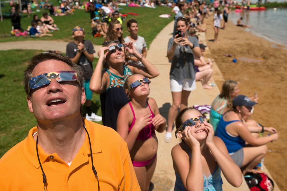 Knox County Mayor Tim Burchett watches for the total solar eclipse in 2017 during a watch party in Tennessee. Special glasses such as the ones those pictured are wearing will be required until the moon fully eclipses the sun and blocks its light.