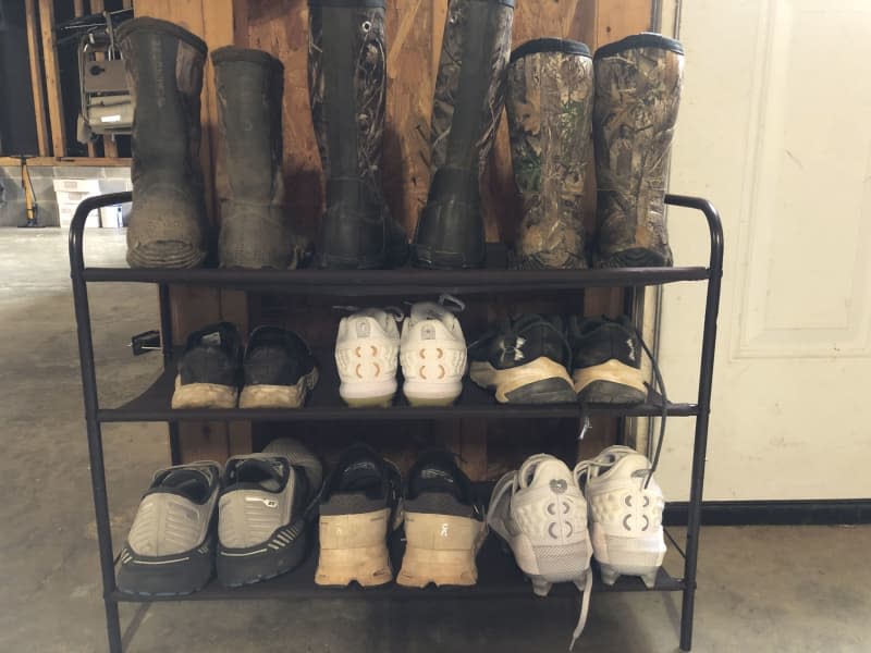 Shoes and boots are organized near entryway.