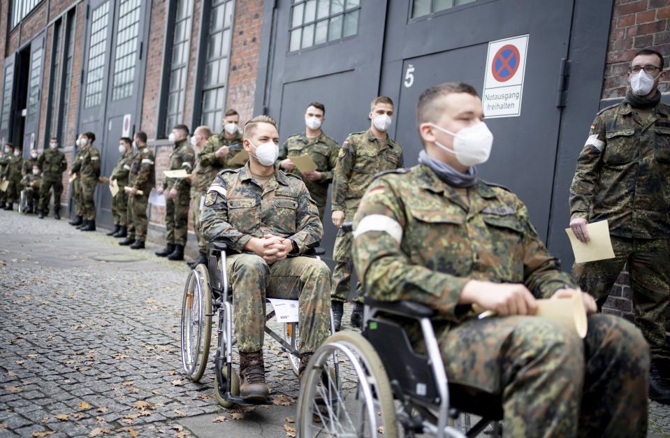 Bundeswehr soldiers taking part of a test run at the vaccination centre against the corona virus at the district Treptow in Berlin, Germany, Wednesday, Dec. 23, 2020. Germany will start to vaccine its the citizen against the coronavirus on Sunday, Dec. 27, 2020. (Kay Nietfeld/dpa via AP)