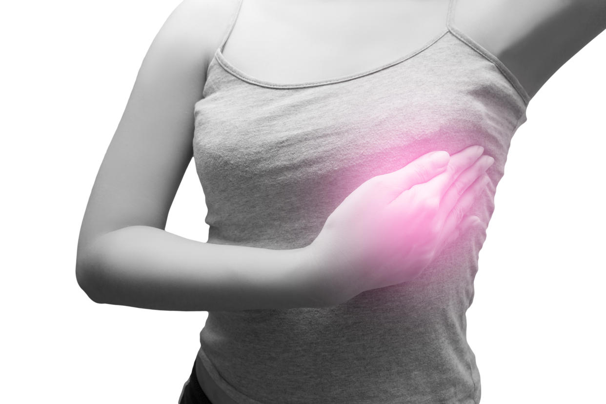 Woman wearing a gray spaghetti strap checking her breast, Isolated on white, Concept of breast self-exam (BSE)