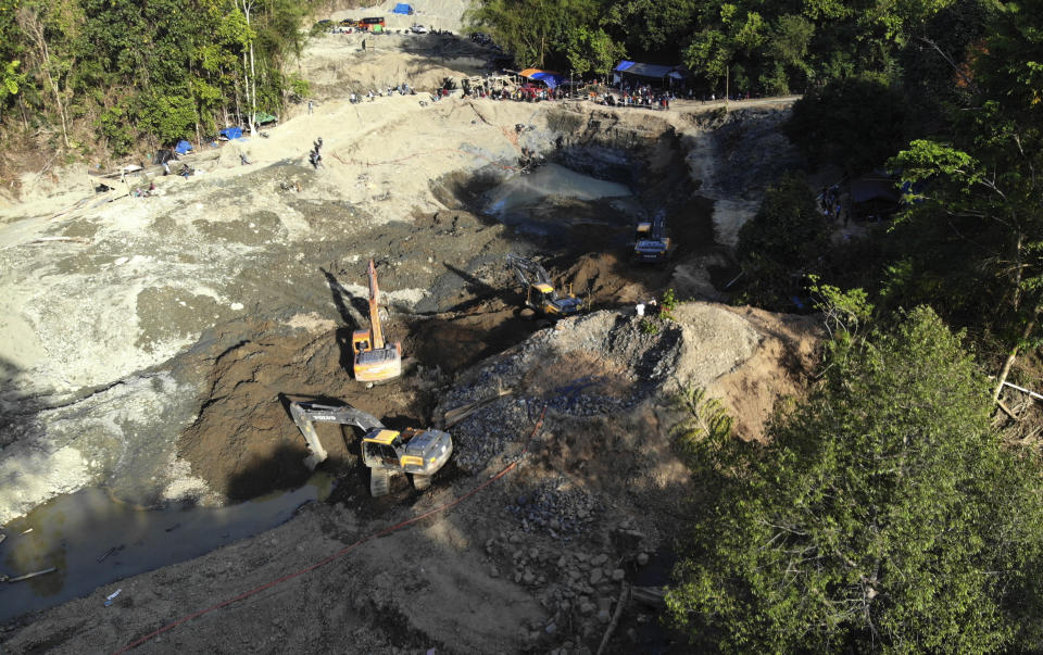 Rescuers use heavy machinery as they search for victims at a collapsed gold mine in Parigi Moutong, Central Sulawesi, Indonesia, Thursday, Feb. 25, 2021. The illegal gold mine in Central Indonesia collapsed on miners working inside, leaving a number of people killed, officials said Thursday. (AP Photo/M. Taufan)