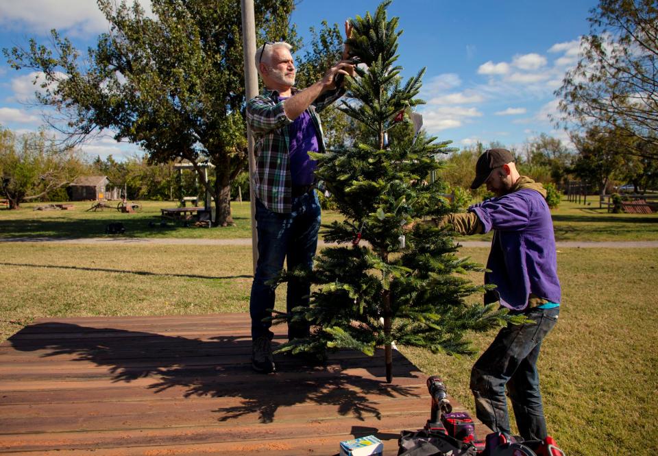 Matthew Sipress and Adam Brand, from left, set up a stage prop for the Lyric Theatre's outdoor production of "A Christmas Carol" at Harn Homestead in Oklahoma City, Okla. on Friday, Nov. 5, 2021. 