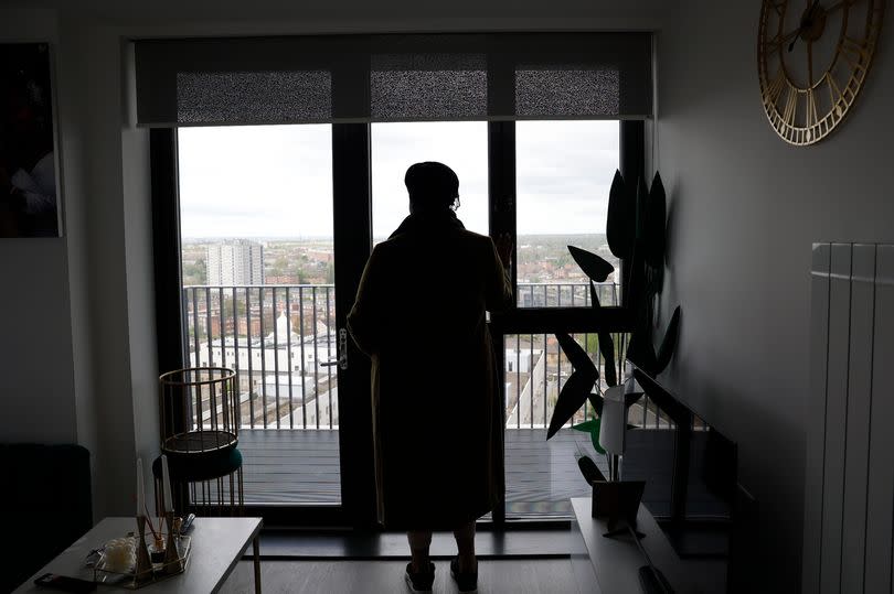 A silhouette photo of a resident in Challingsworth House (looking out onto a balcony