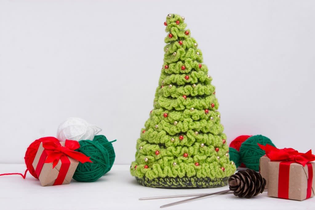 A green Christmas tree is made from yarn.