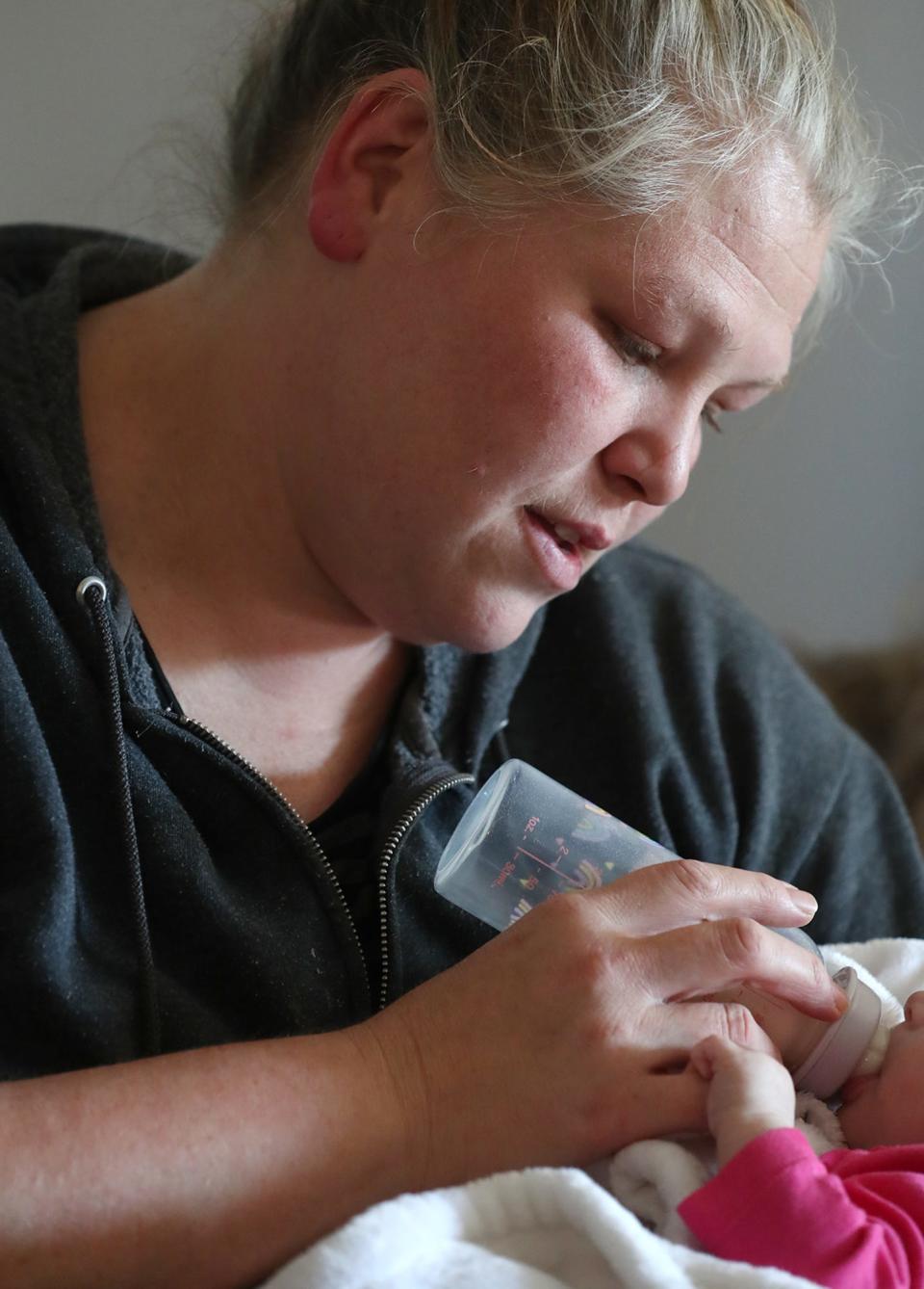 Nicole Welch feeds her 4-month-old foster baby at her home in Green. Welch said she's not opposed to the county's needle exchange program itself but that its clients share a waiting room with WIC clients in Akron.