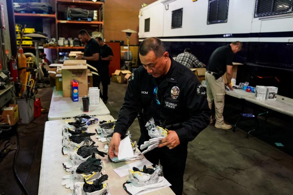 LAPD Lt. Jay Hom assembles coronavirus kits consisting of an N95 mask, goggles, leather gloves and rubber gloves. The kits are going out to about 7,000 officers who work in the field.
