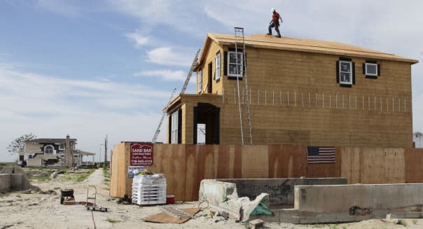 Superstorm Sandy Breezy Point (A worker walks the roof line of a house under construction in the Breezy Point community of New Y