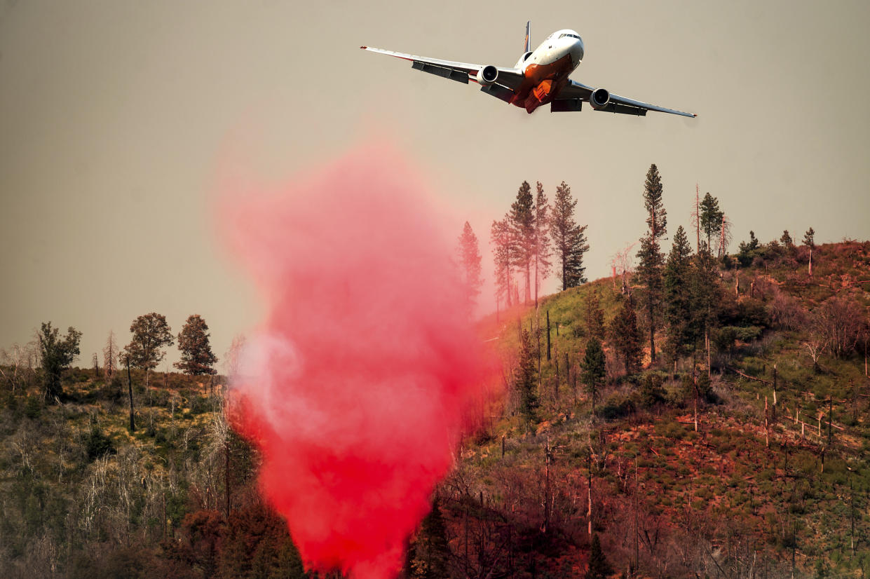 An air tanker drops retardant while trying to stop the Oak Fire from reaching the Lushmeadows community in Mariposa County, Calif., on Sunday, July 24, 2022. (AP Photo/Noah Berger)