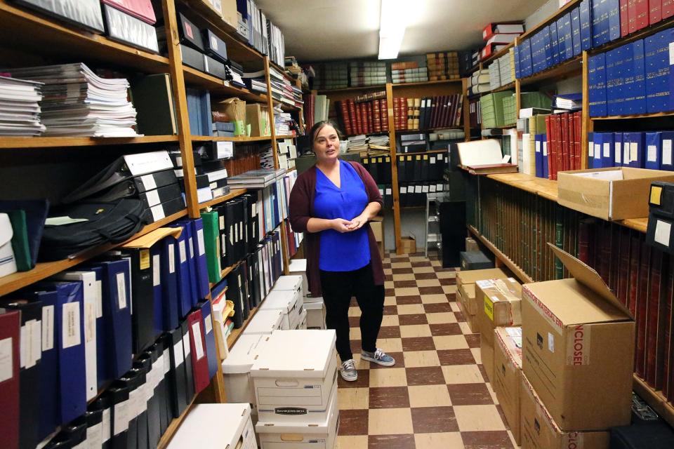 Kennebunkport’s Town Hall vault is crammed with vital and historic documents. Hope Mowry, communications and event specialist, shows how the vault is also vulnerable to water damage from two pipes that run above it.