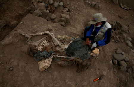 Archaeologist works at a tomb of one of sixteen Chinese migrants, discovered buried at the turn of the 20th century in the pre-colombian pyramid of Bellavista, according to Ministry of Culture, in Lima, Peru, August 24, 2017. REUTERS/Mariana Bazo