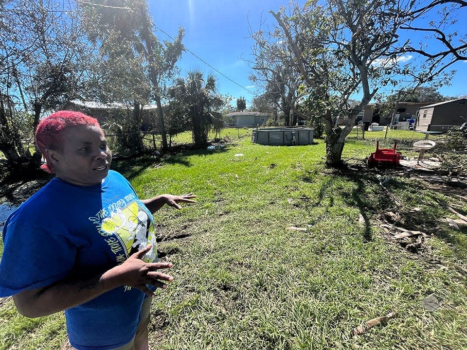 Lorrieann Thurman shows damage in her backyard in the Dunbar area of Fort Myers from Hurricane Ian on Sept. 30, 2022.