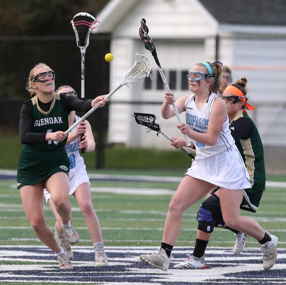 Evelyn Parr (left) of GlenOak fights for the ball with Kalli Spehar (right) of Louisville during Wednesday's girls lacrosse game.