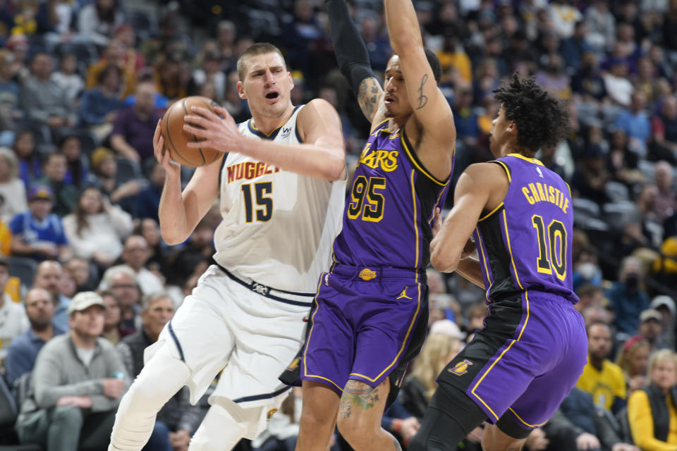 Denver Nuggets center Nikola Jokic, left, drives to the basket as Los Angeles Lakers forward Juan Toscano-Anderson, center, and guard Max Christie defend in the first half of an NBA basketball game Monday, Jan. 9, 2023, in Denver. (AP Photo/David Zalubowski)