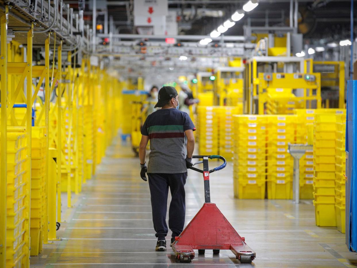 An employee pulls a cart at Amazon's JFK8 distribution center in Staten Island, New York, U.S. November 25, 2020.