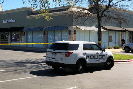 A police officer and a cruiser is seen at a FedEx store which is closed, with police saying it may be linked to the overnight bomb at Schertz, Texas FedEx facility, in Austin, Texas, U.S., March 20, 2018. REUTERS/Jon Herskovitz