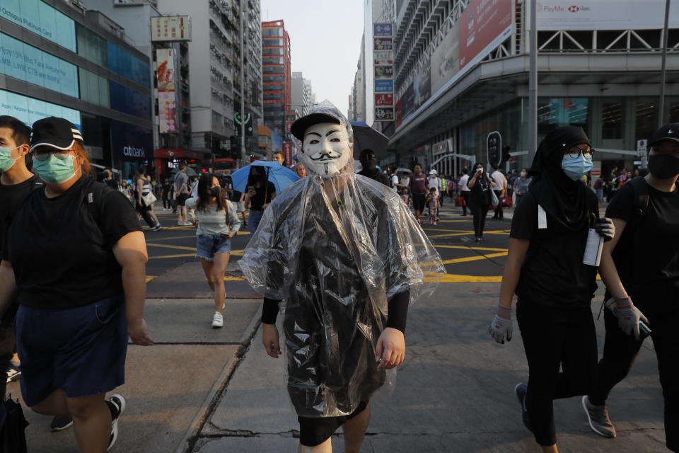 Protesters with face masks walk on a road during a protest in Hong Kong, Saturday, Oct. 12, 2019. The protests that started in June over a now-shelved extradition bill have since snowballed into an anti-China campaign amid anger over what many view as Beijing's interference in Hong Kong's autonomy that was granted when the former British colony returned to Chinese rule in 1997. (AP Photo/Kin Cheung)