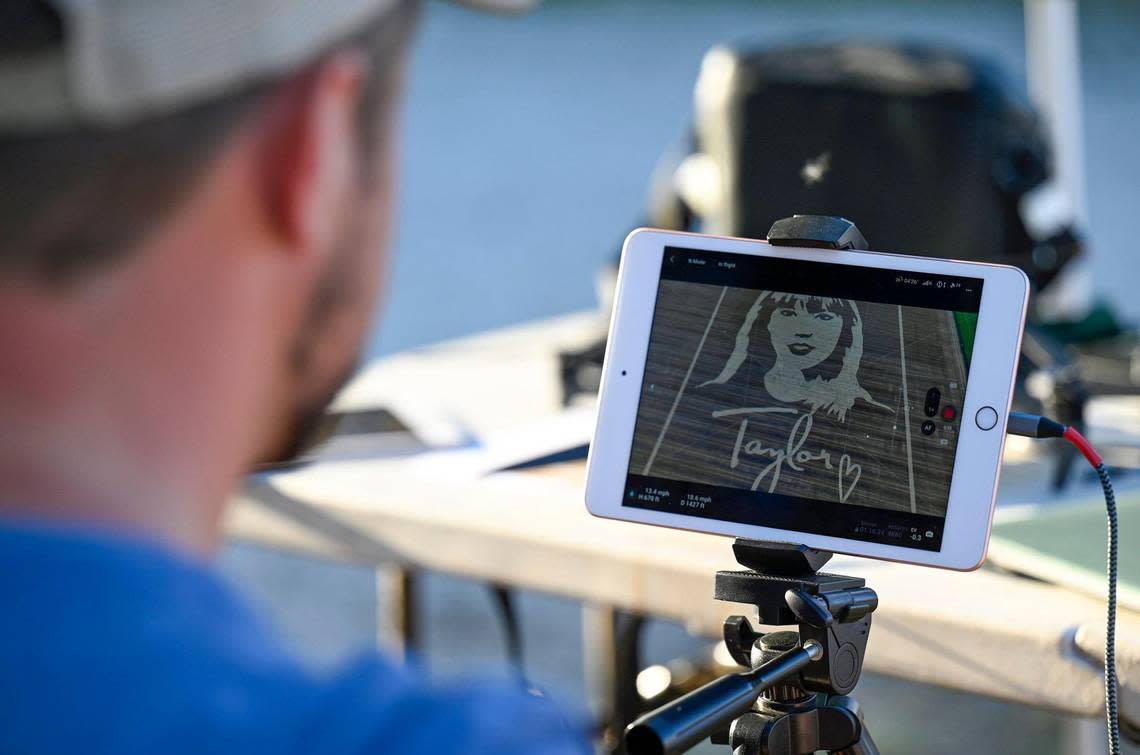 A member of the drone team monitors the video being shot as Rob Stouffer of Precision Mazes, cuts a welcome message to Taylor Swift in a field of wheat stubble on Monday, July 3, 2023, in Orrick, Missouri.