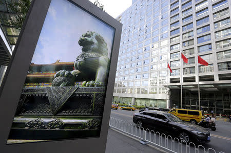 An advertising board (L) showing a Chinese stone lion is pictured near an entrance to the headquarters (R) of China Securities Regulatory Commission (CSRC), in Beijing, China, September 7, 2015. REUTERS/Jason Lee/File Photo