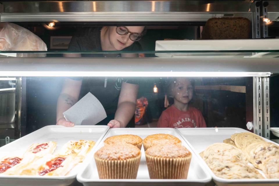 Heather Williams and her 3-year-old son, Arthur, arrange the fresh baked goods in their counter Thursday morning at The Forgotten Grain Bistro & Bakery. Williams and her husband, Konr, started the bakery in 2021 and are expanding into the space adjacent.