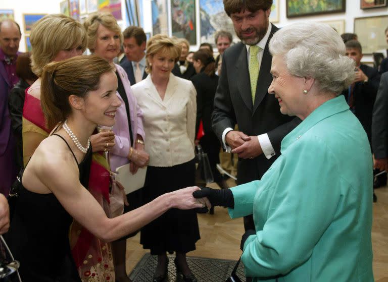 La reina Isabel II saluda a la bailarina Darcey Bussell en la Royal Academy para conmemorar su Jubileo de Oro el 22 de mayo de 2002 en Londres