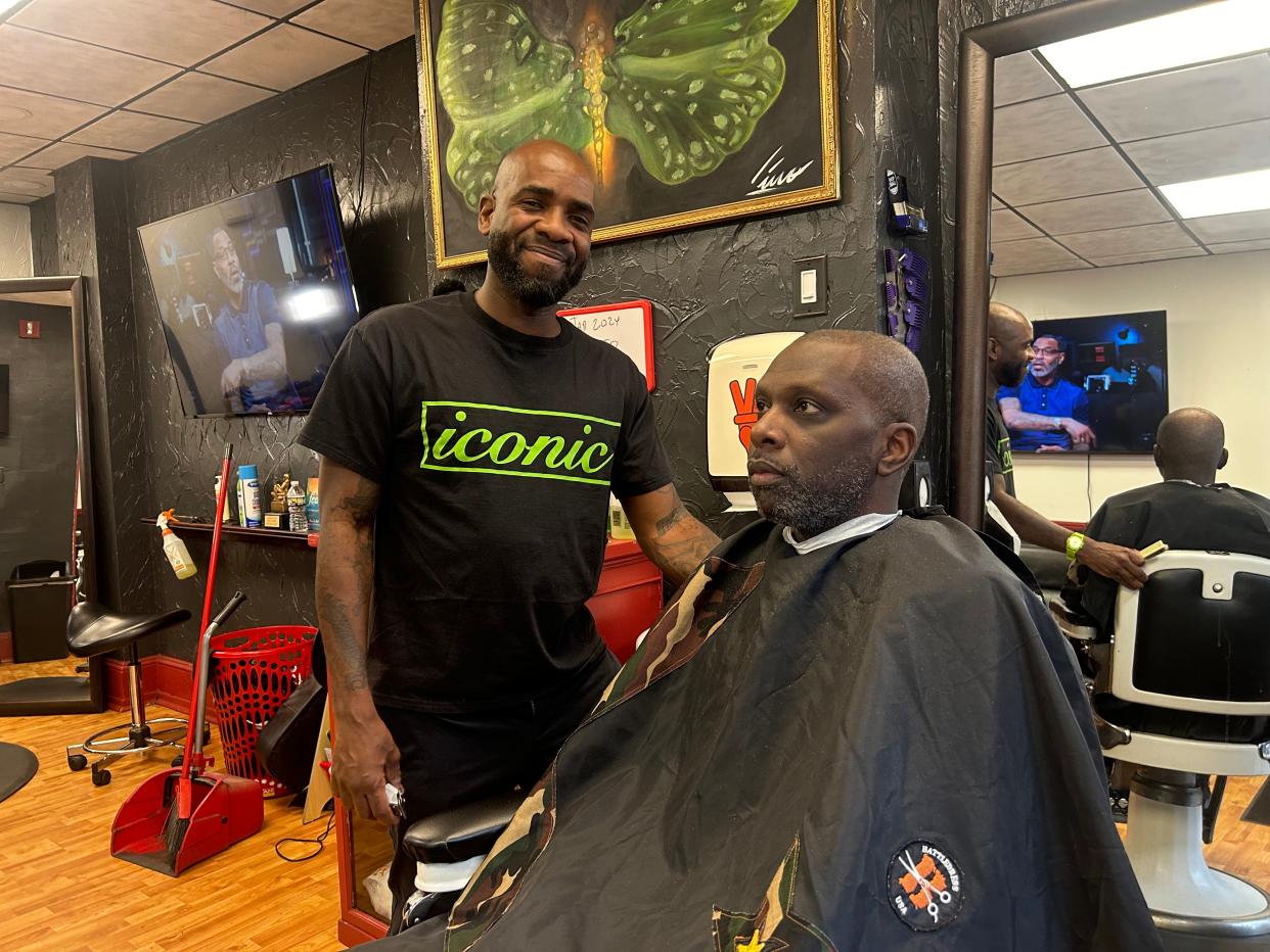 Wanza Poole, owner/operator of Iconic Barber in the Germantown neighborhood in Philadelphia, and his client and friend James Blakely often discuss books they've read.