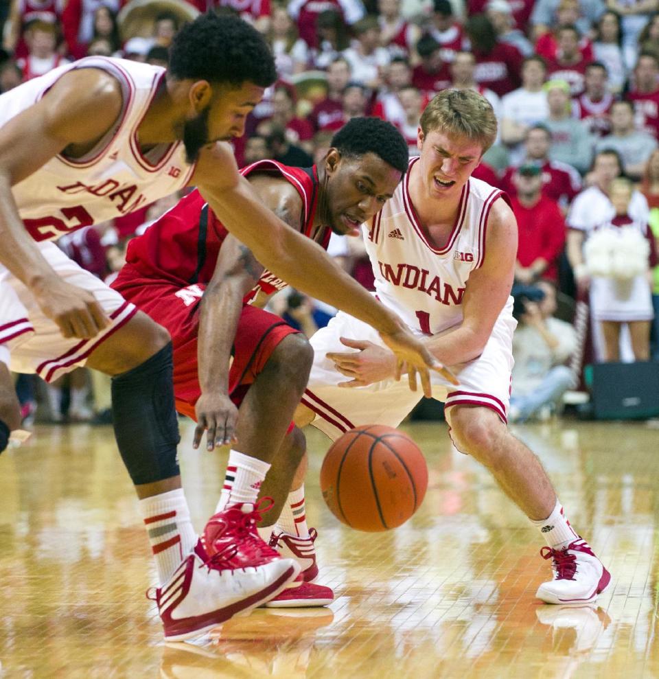 Nebraska's Benny Parker, center, battles for the ball with Indiana's Christian Watford (2) and Jordan Hulls (1) during the second half of an NCAA college basketball game, Wednesday, Feb. 13, 2013, in Bloomington, Ind. Indiana won 76-47. (AP Photo/Doug McSchooler)