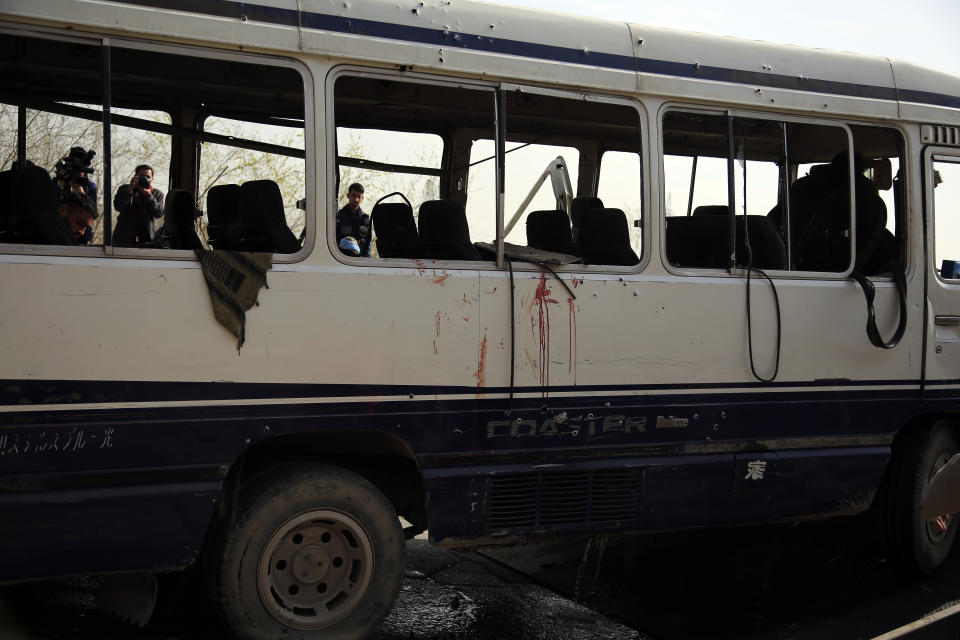 Media take vide3o and photos of a damaged minibus after a bomb explosion in Kabul Afghanistan, Thursday, March 18, 2021. The bus attack caused numerous deaths and injuries according to police. (AP Photo/Mariam Zuhaib)