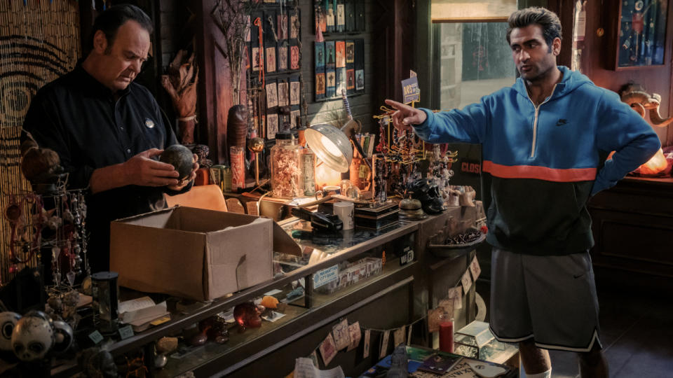 Dan Aykroyd examines an artifact in the bookshop while Kumail Nanjiani is speaking to him in Ghostbusters: Frozen Empire.