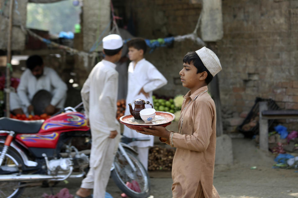 FILE - A Pakistani boy works at a tea shop in Peshawar, Pakistan, Sunday, June 12, 2022. Planning Minister Ahsan Iqbal in Pakistan's newly elected government faced criticism Wednesday, June 15, 2022, following his plea to the nation to drink less tea to help save on imports amid a deepening economic crisis. Pakistan is among the world's top tea importers, a hugely popular drink among both the rich and the poor in this country of 220 million people. (AP Photo/Mohammad Sajjad, File)