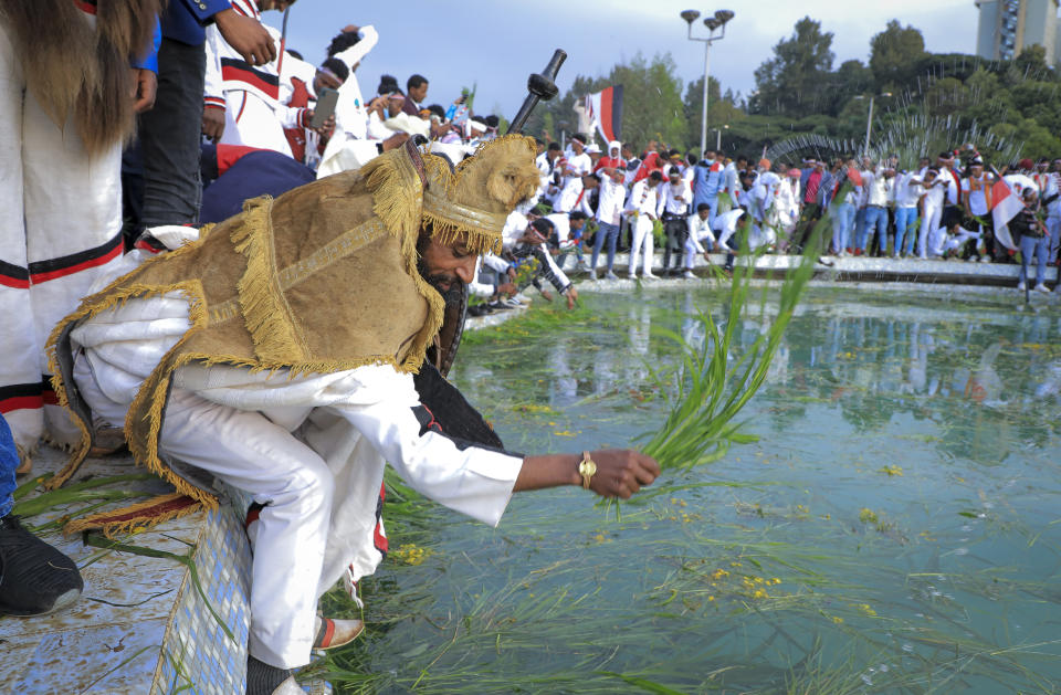 Oromos throw grass and flowers into a pool of water as they celebrate the annual Irreecha festival in the capital Addis Ababa, Ethiopia, Saturday, Oct. 2, 2021. Ethiopia's largest ethnic group, the Oromo, on Saturday celebrated the annual Thanksgiving festival of Irreecha, marking the end of winter where people thank God for the blessings of the past year and wish prosperity for the coming year. (AP Photo)