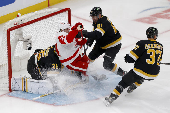 Detroit Red Wings center Pius Suter (24) crashes into Boston Bruins goaltender Linus Ullmark (35) ahead of Bruins defenseman Dmitry Orlov (81) during the first period of an NHL hockey game, Saturday, March 11, 2023, in Boston. (AP Photo/Mary Schwalm)