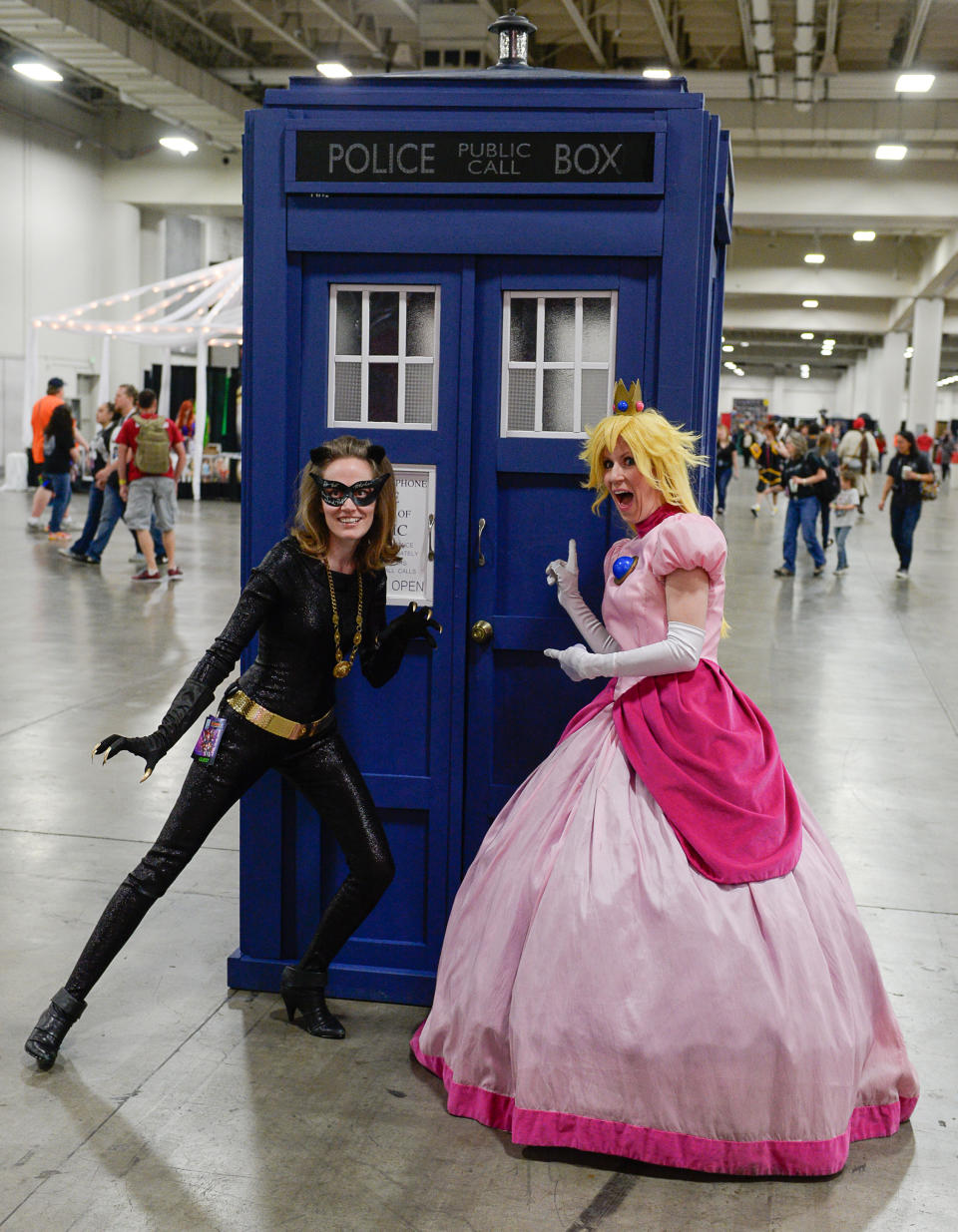 Heidi Mason as "Catwoman," and Winter Thayne as "Princess Peach," get their Dr. Who on as they join thousands of fiction fans from near and far gathered at the Salt Palace Convention Center in Salt Lake City, Utah, Friday, April 18, 2014, for day two of Salt Lake Comic Con's FanX. (AP Photo/The Salt Lake Tribune, Francisco Kjolseth)