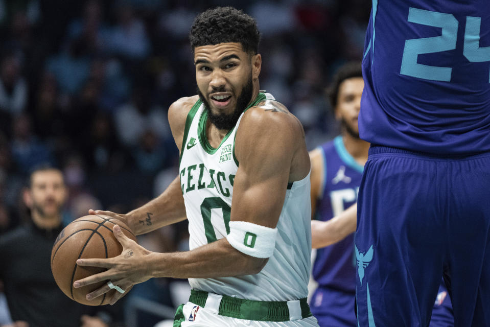 Boston Celtics forward Jayson Tatum (0) moves around Charlotte Hornets center Mason Plumlee (24) during the first half of an NBA basketball game in Charlotte, N.C., Monday, Oct. 25, 2021. (AP Photo/Jacob Kupferman)