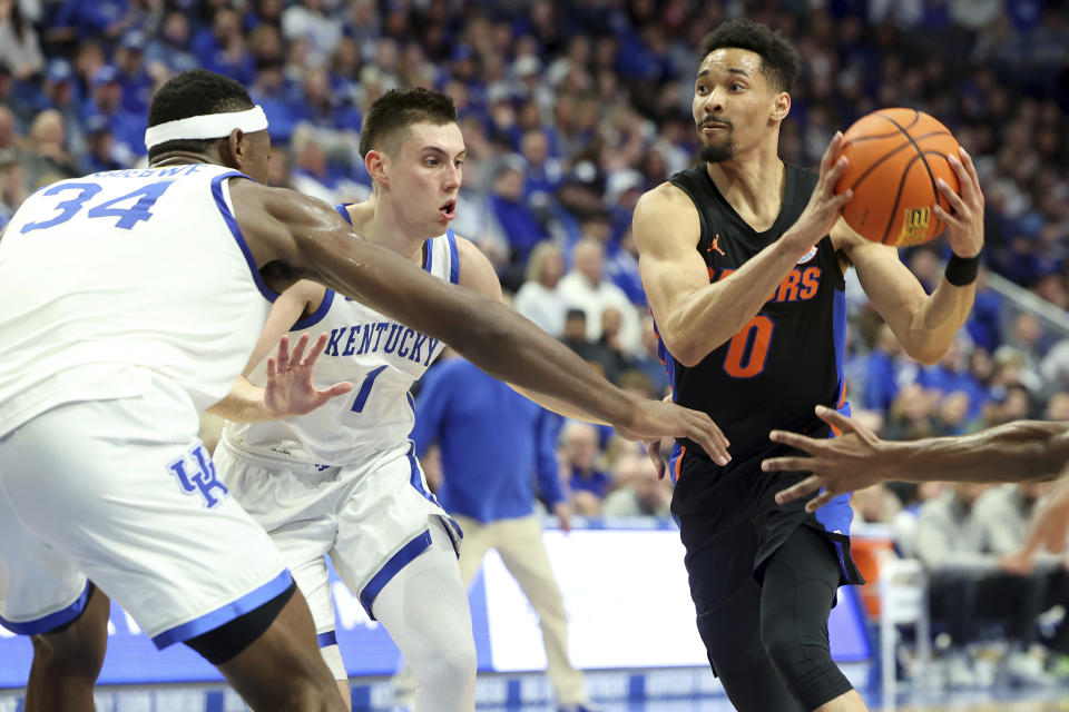 Florida's Myreon Jones (0) looks for a teammate near Kentucky's CJ Fredrick (1) and Oscar Tshiebwe (34) during the second half of an NCAA college basketball game in Lexington, Ky., Saturday, Feb. 4, 2023. (AP Photo/James Crisp)