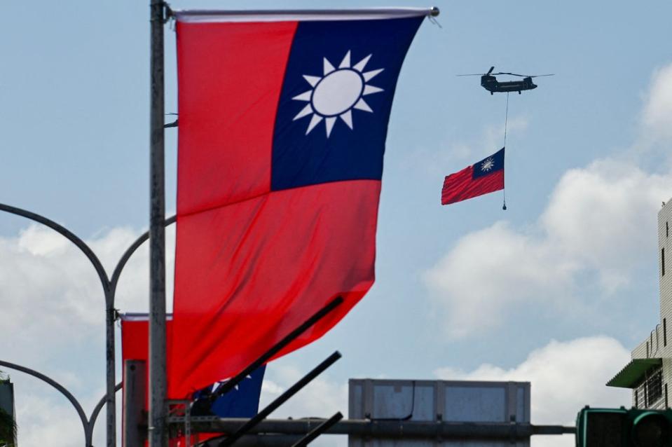 A CH-47 Chinook helicopter carries a Taiwan flag during national day celebrations in Taipei on 10 October 2021 (AFP via Getty Images)