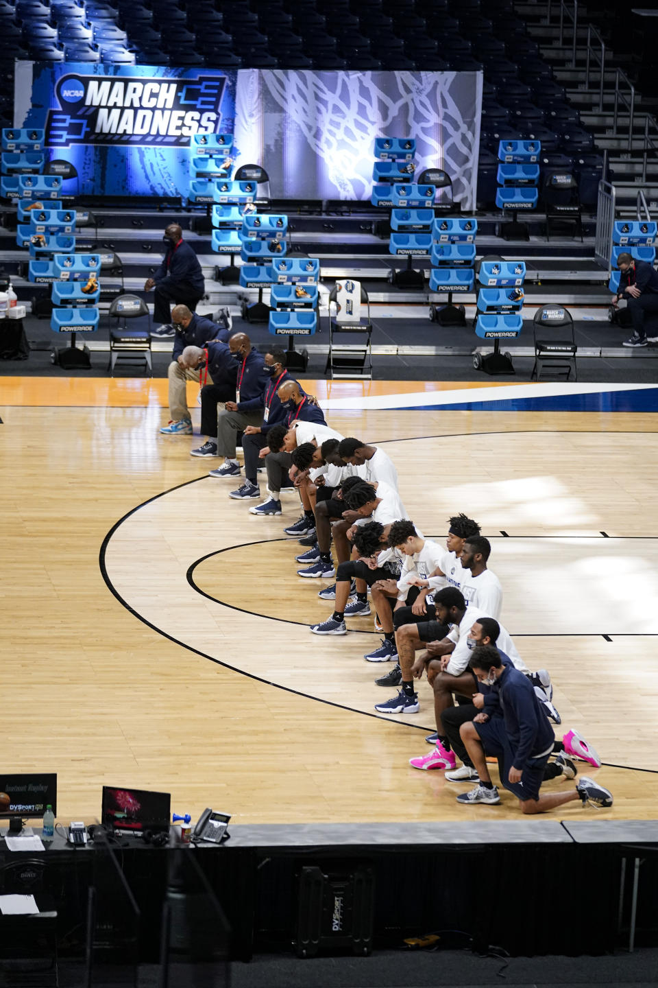 Members of the Georgetown team take a knee during the National Anthem before a first-round game against Colorado in the NCAA men's college basketball tournament at Hinkle Fieldhouse in Indianapolis, Saturday, March 20, 2021. Colorado defeated Georgetown 96-73. Restrictions due to the COVID-19 pandemic have limited crowds, reduced interactions and created an abnormal NCAA experience for those involved. (AP Photo/Michael Conroy)