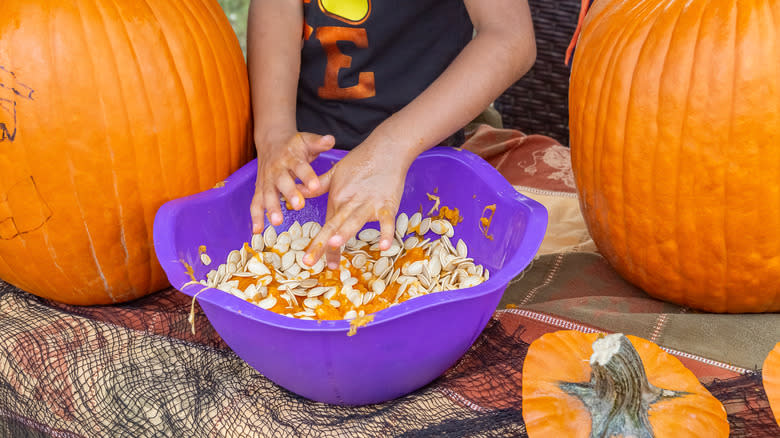 Putting pumpkin seeds in bowl