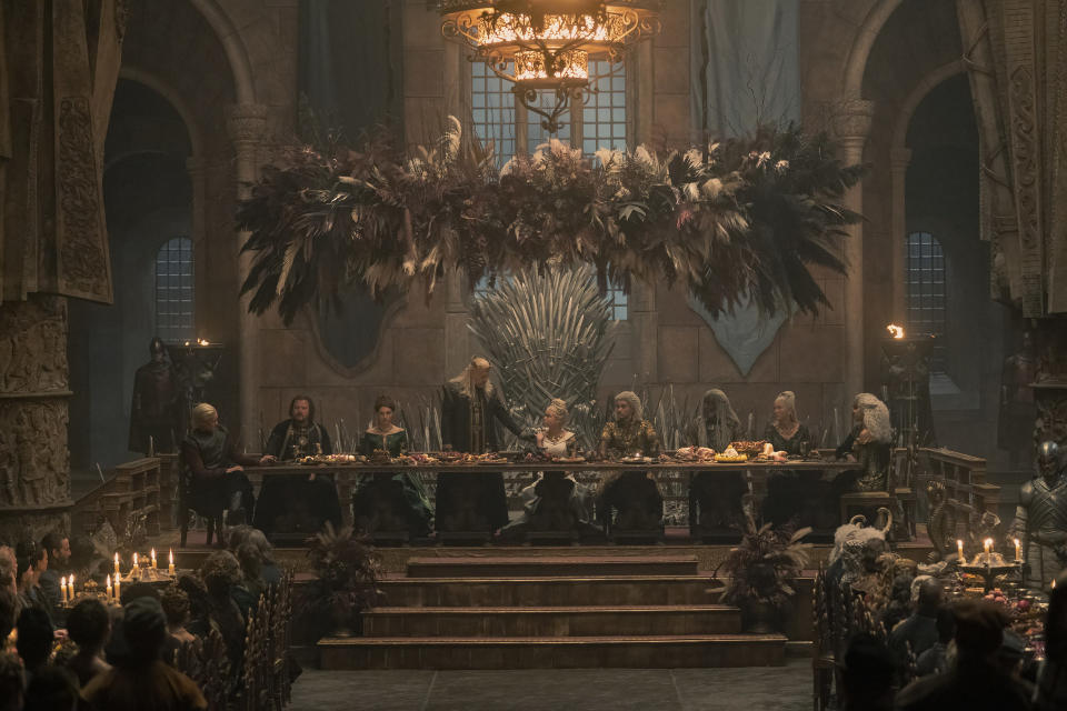 Viserys stands next to Rhaenyra at the head table during Rhaenyra and Laenor's engagement feast in the Throne Room