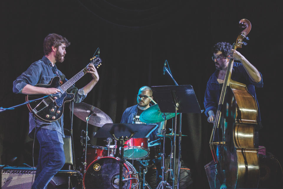 Max Light, performing onstage with his band