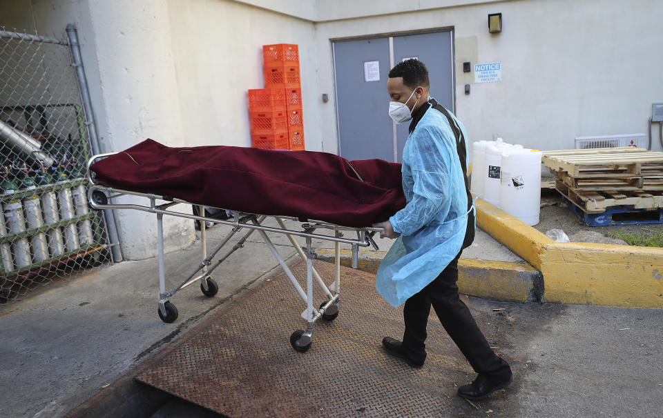 Preston Griffin, who runs First Class Mortuary Transport, wear protective gear as he leaves area nursing home with a body in Philadelphia, Pa. on May 7, 2020. (David Maialetti/The Philadelphia Inquirer via AP)