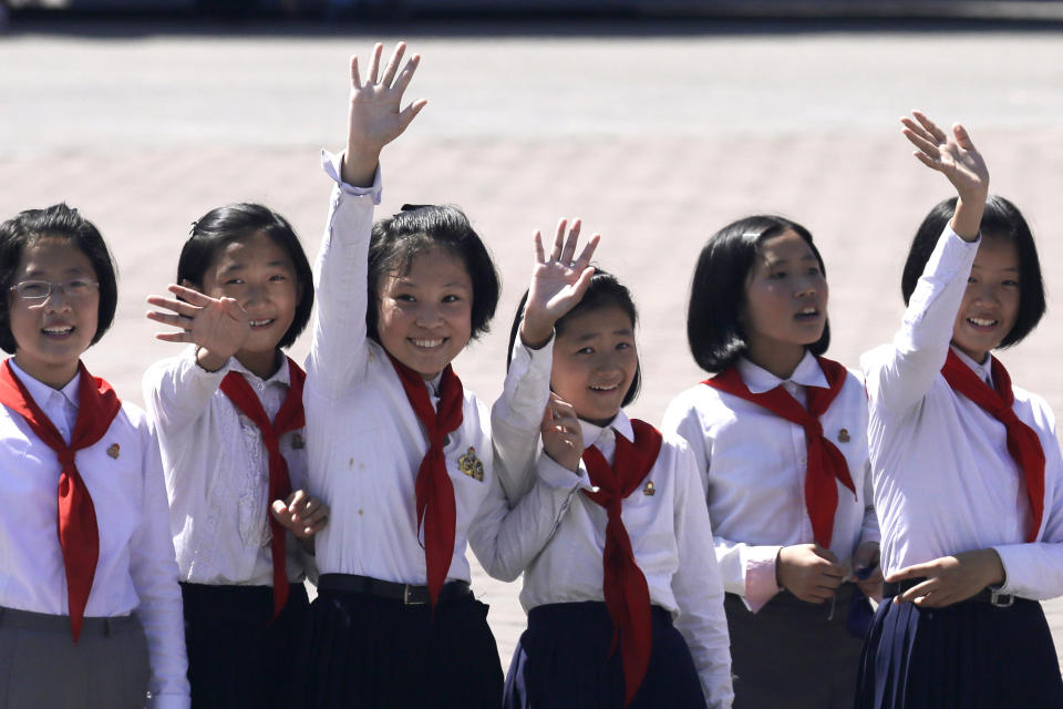 Students wave to a bus carrying foreign journalists after a parade marking the 70th anniversary of North Korea's founding day in Pyongyang, North Korea, Sunday, Sept. 9, 2018. North Korea staged a major military parade, huge rallies and will revive its iconic mass games on Sunday to mark its 70th anniversary as a nation. (AP Photo/Kin Cheung)
