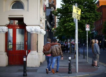 Men walk past a no vote campaign poster in central Dublin as Ireland holds a referendum on gay marriage, May 22, 2015. REUTERS/Darren Staples