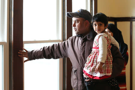 MD Chowdhury stands with his wife, Nazneen Fatema, and daughter, Nafia, 2, during an interview about lead safety improvements made to their lead contaminated home in Buffalo, New York March 30, 2017. REUTERS/Lindsay DeDario