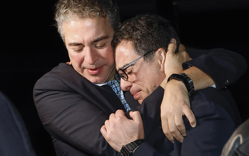 A family member embraces freed American Siamak Namazi after he and four fellow detainees were released in a prisoner swap deal. The image is a closeup of two people embracing and smiling, with their eyes closed.