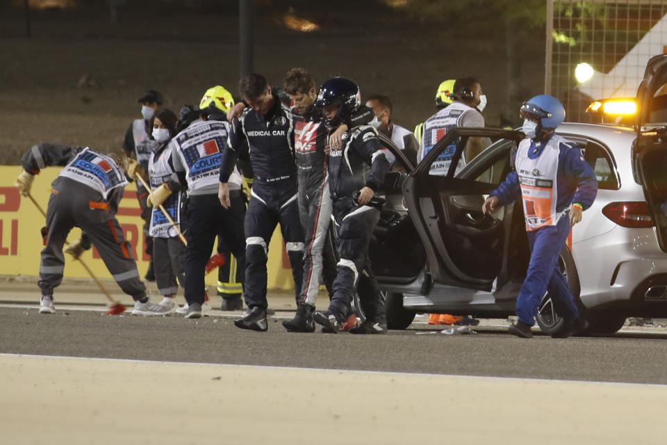 El piloto francés Romain Grosjean del equipo Haas es asistido tras accidentarse en el Gran Premio de Bahréin, el domingo 29 de noviembre de 2020, en Sakhir. (Hamad Mohammed, Pool vía AP)